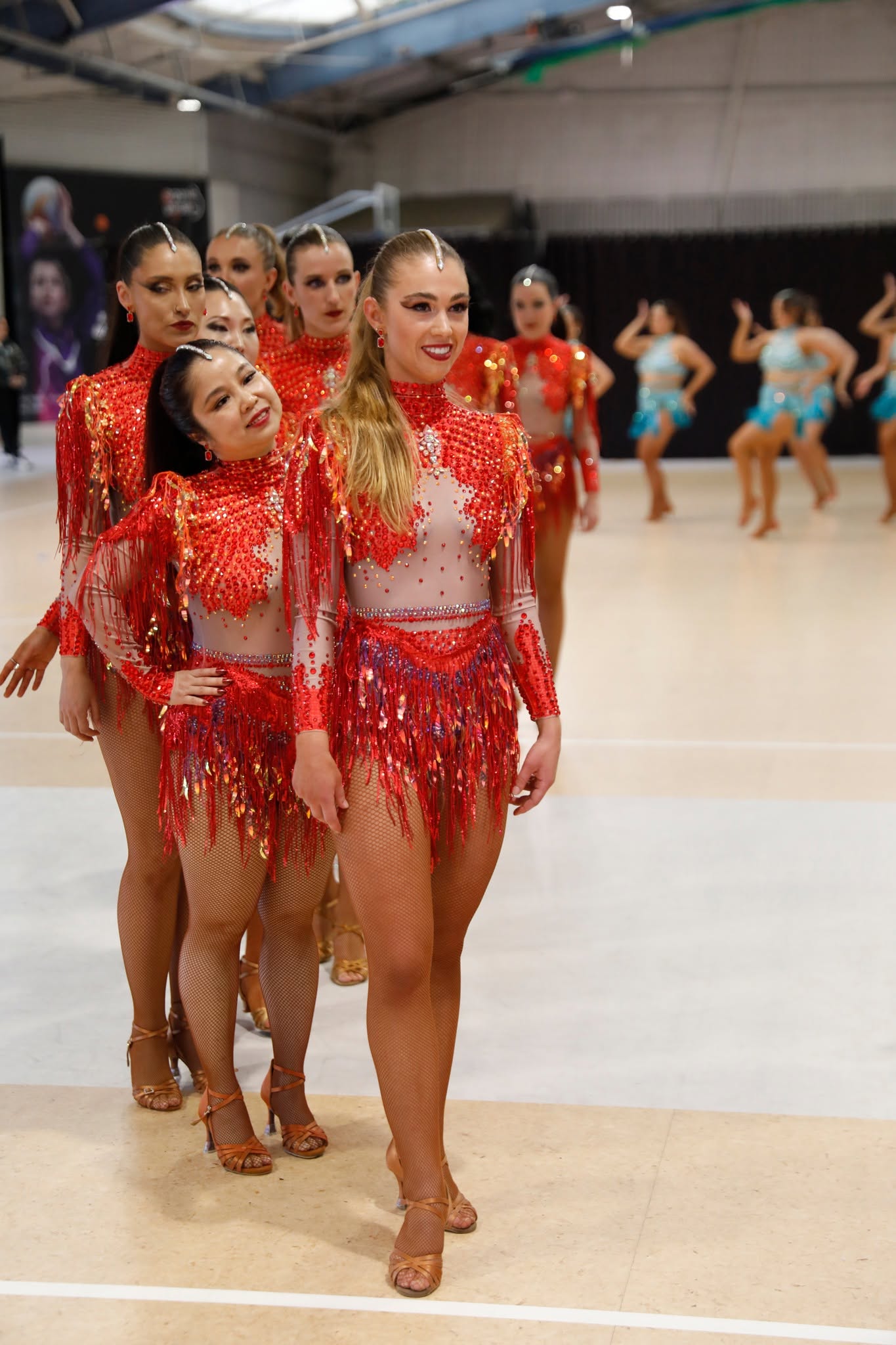 Team in red sequin costumes walking in formation