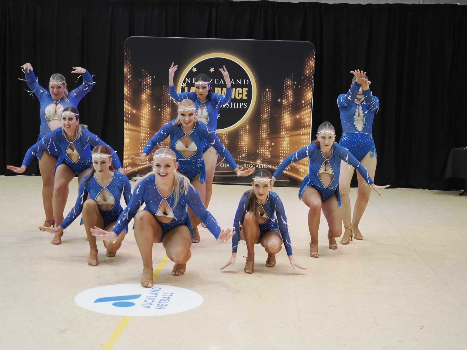 Team in blue costumes in a tiered formation