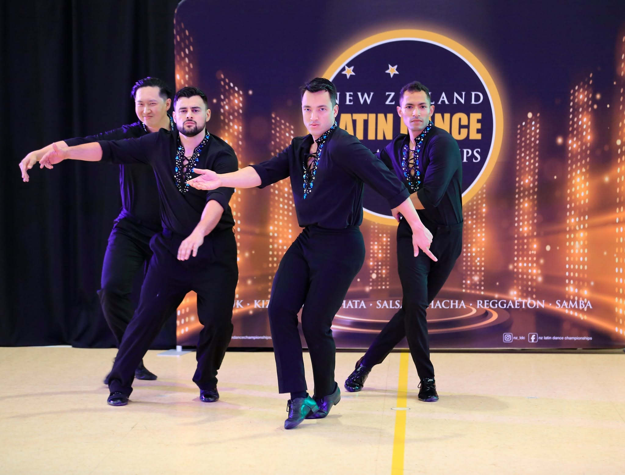 Team of men in black Latin shirts in a synchronized pose